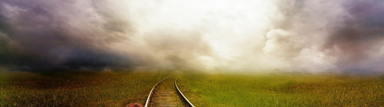 Boy looking down railroad tracks